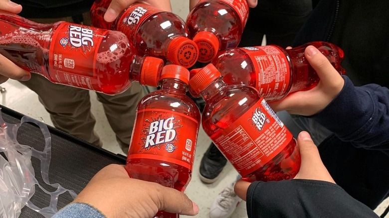 Hands holding Big Red bottles together