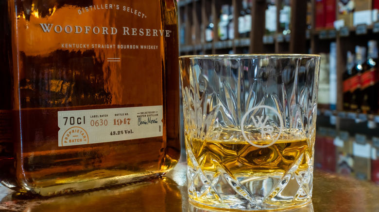 woodford reserve bottle next to a glass of bourbon