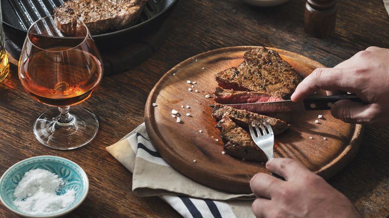 cooked steak and glass of bourbon