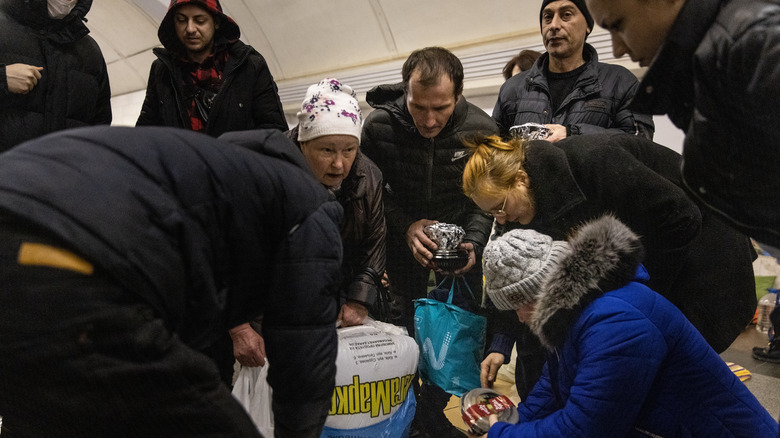 volunteers pass out food in a Kyiv bomb shelter