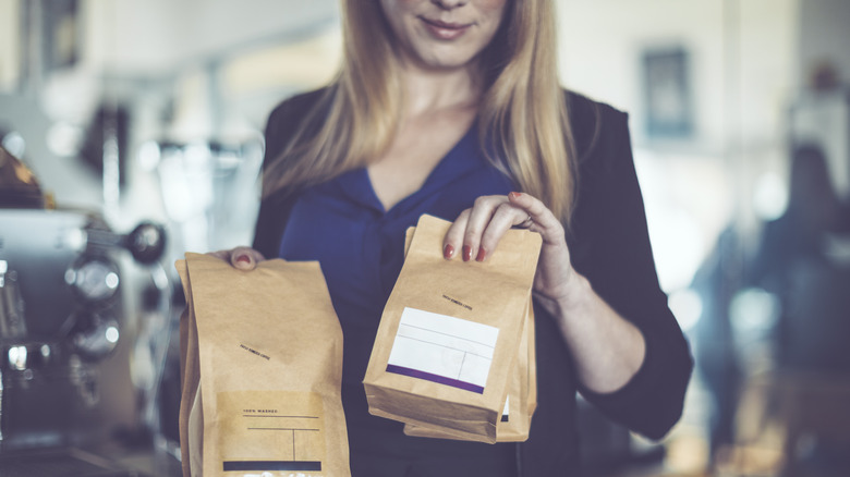 Person carrying small coffee bags