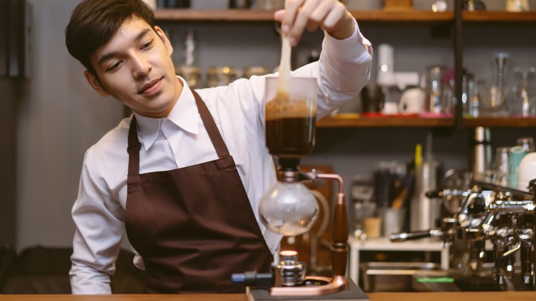 Barista making siphon coffee