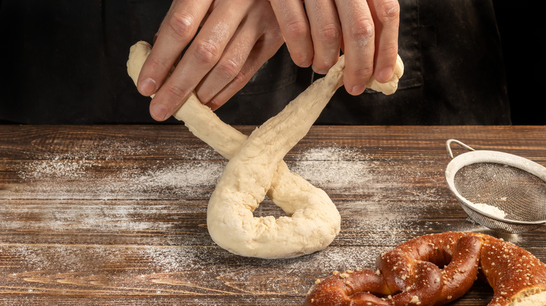 baker making pretzel with dough