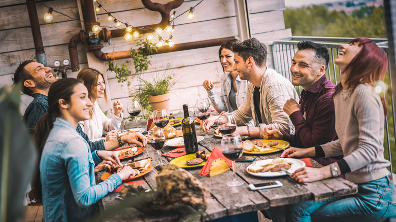 Outdoor table full of dinner party guests