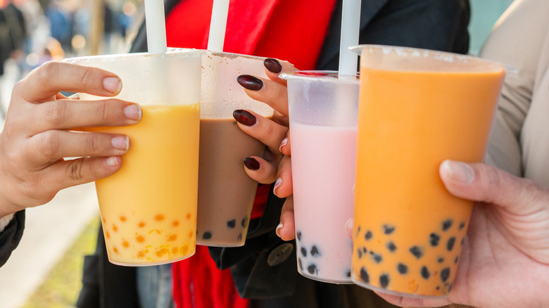 People holding various colors and flavors of bubble tea