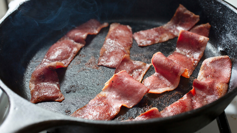 turkey bacon frying in skillet