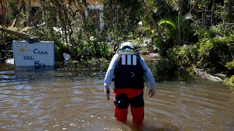 a relief worker wades flood