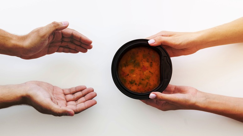 Hands offering soup