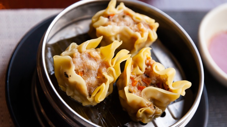 closeup of pork shumai in a round tin steambox