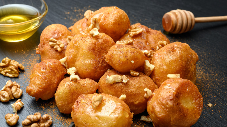 Loukoumades coated in honey and walnuts on a plate