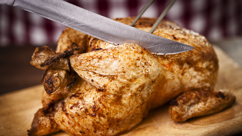 Knife cutting into a chicken
