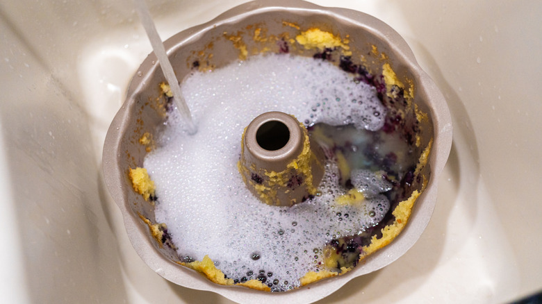 soaking pan in soapy water