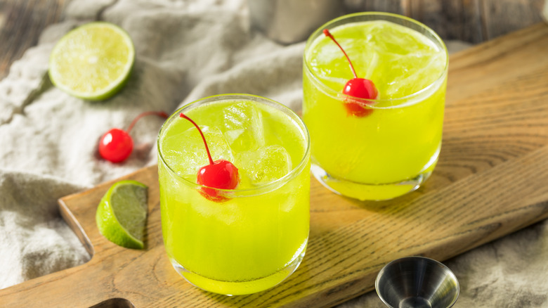 green cocktails garnished with cherries