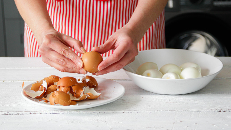 Home cook peeling boiled eggs