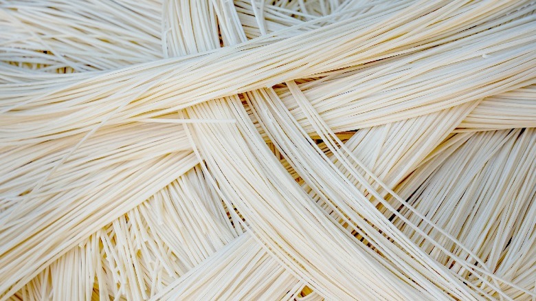 Fresh Chinese long noodles piled in stacks on a table