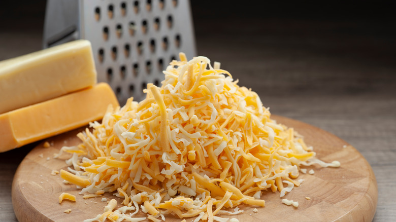 Different shredded cheeses on board