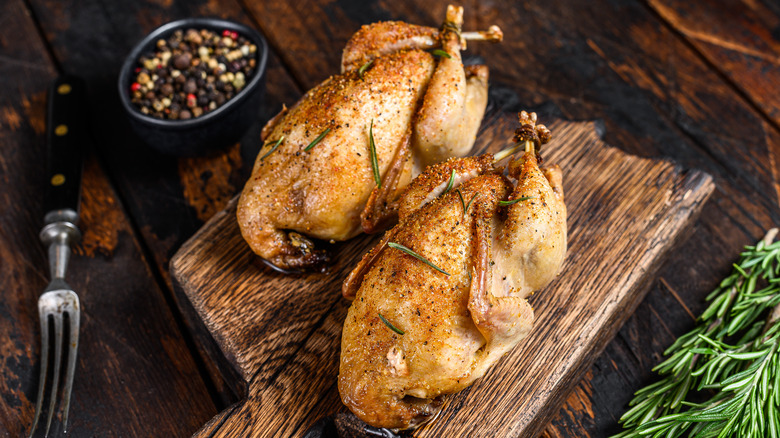 two roasted quails on wood