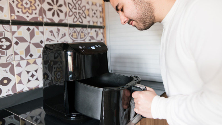 man looking in air fryer