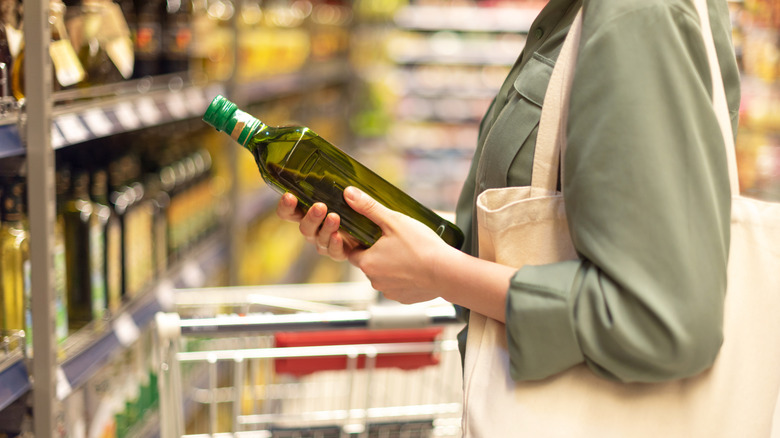 Person buying bottled olive oil