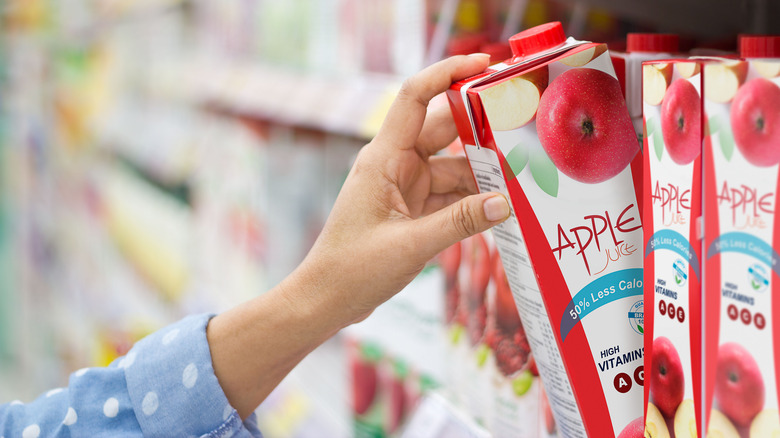 hand grabbing apple juice carton