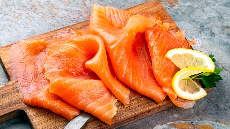 Smoked salmon with lemon on wooden board