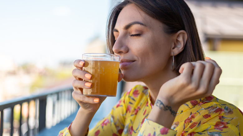 Person drinking a glass of kombucha