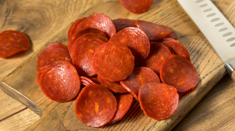 Pile of pepperoni slices on a cutting board