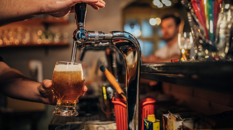 pouring beer from keg tap