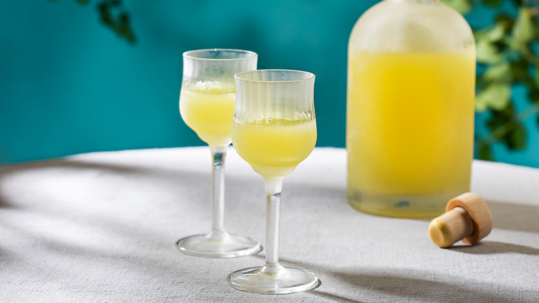 glasses of limoncello with an uncorked bottle