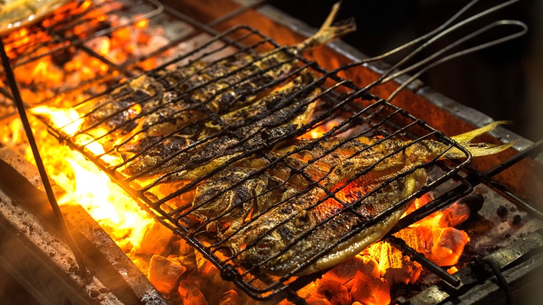 speared whole fish on a grill rack