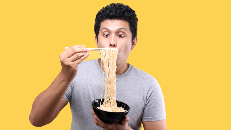 Person eating ramen with chopsticks