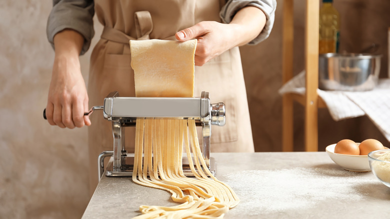 Woman using pasta maker