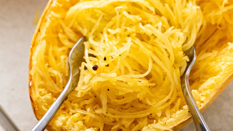 Close-up of forks fluffing cooked spaghetti squash