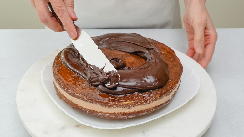 spreading ganache on cake