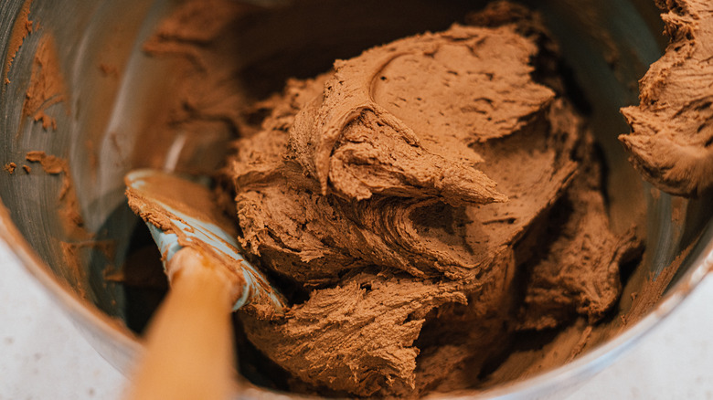 spoon stirring chocolate frosting