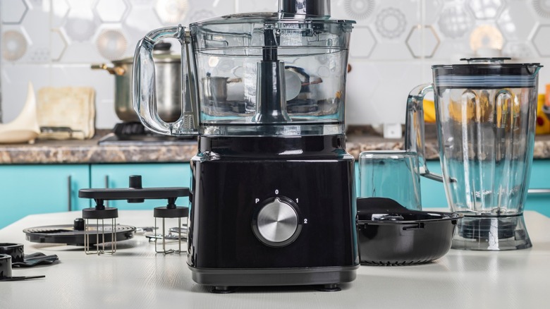 A food processor on a counter among other kitchen appliances