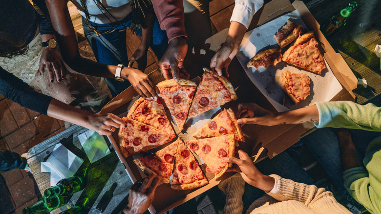 people eating slices of pizza