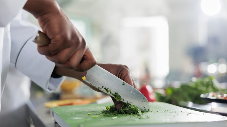 a chef chops herbs