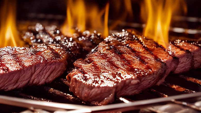 steaks cooking on the grill