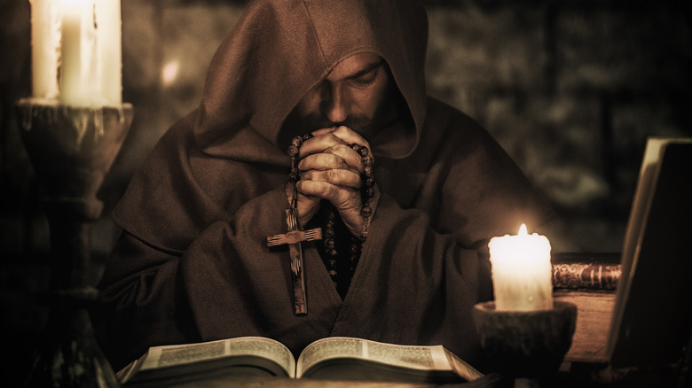 a monk praying by candlelight