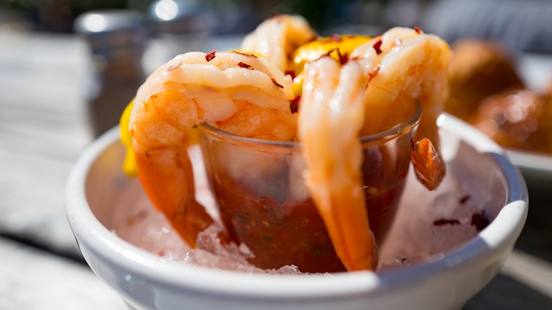 four shrimp cocktail on ice with lemon