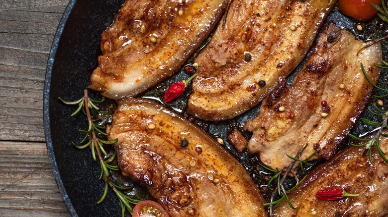 browned pork belly slices in pan