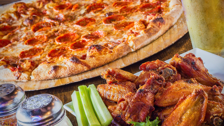 Table packed with pizza and wings