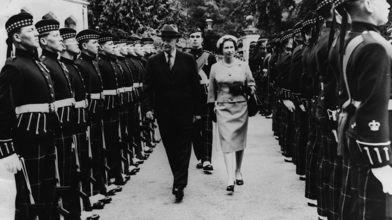 Queen Elizabeth and President Eisenhower walking, guards