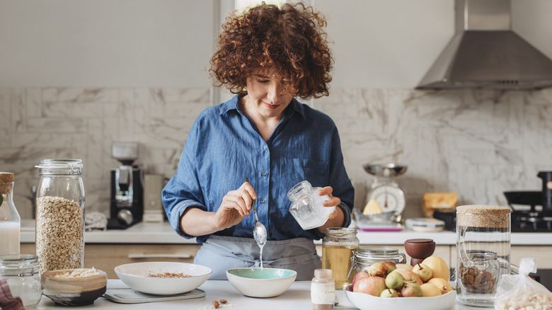 woman cooking with bowls of oats