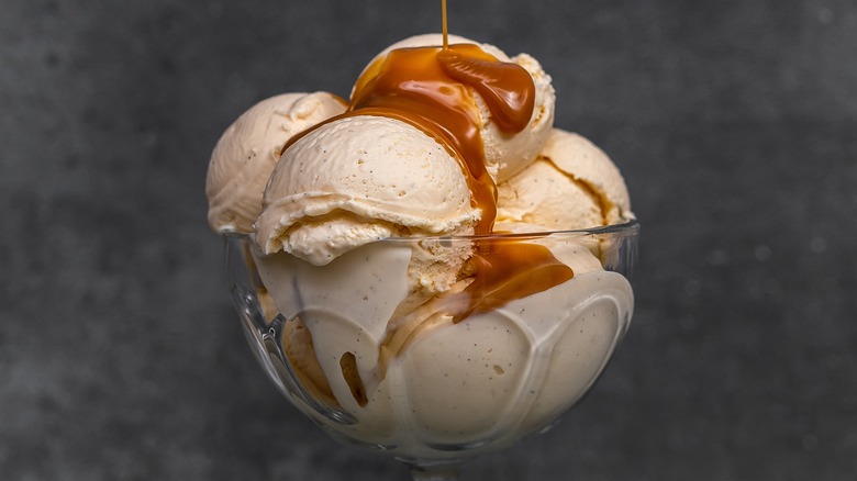 salted caramel over scoop of vanilla in a glass serving dish