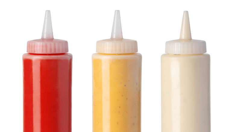 Three condiments in squeeze bottles 