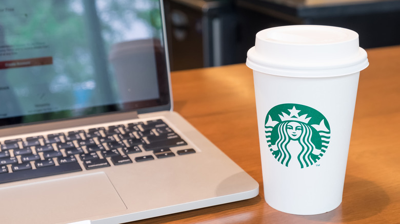 Starbucks coffee by computer screen
