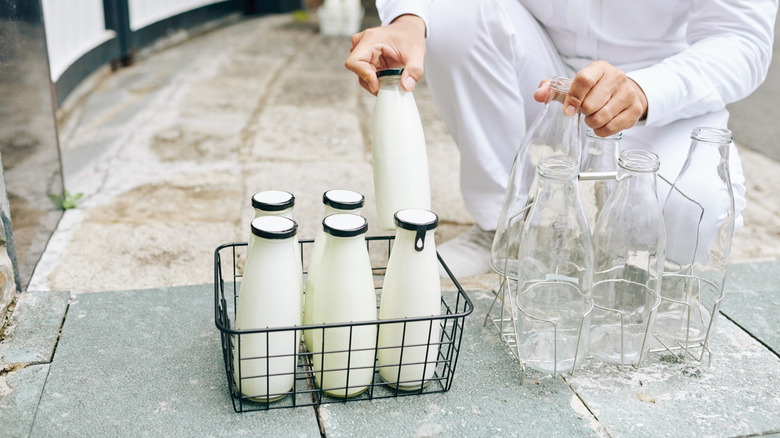 milkman delivering milk bottles in basket 