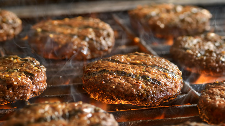 Ground beef patties sizzling grill 